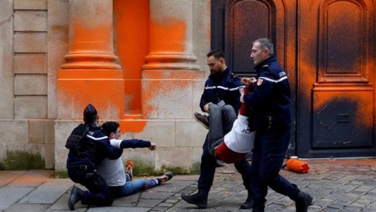 法国气候活动人士当警察面往总理府门上喷漆 当场被逮捕架走