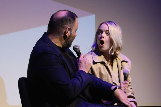 "Emma Stone Shines at Film Festival: Khaki Coat Paired with Black Stockings"